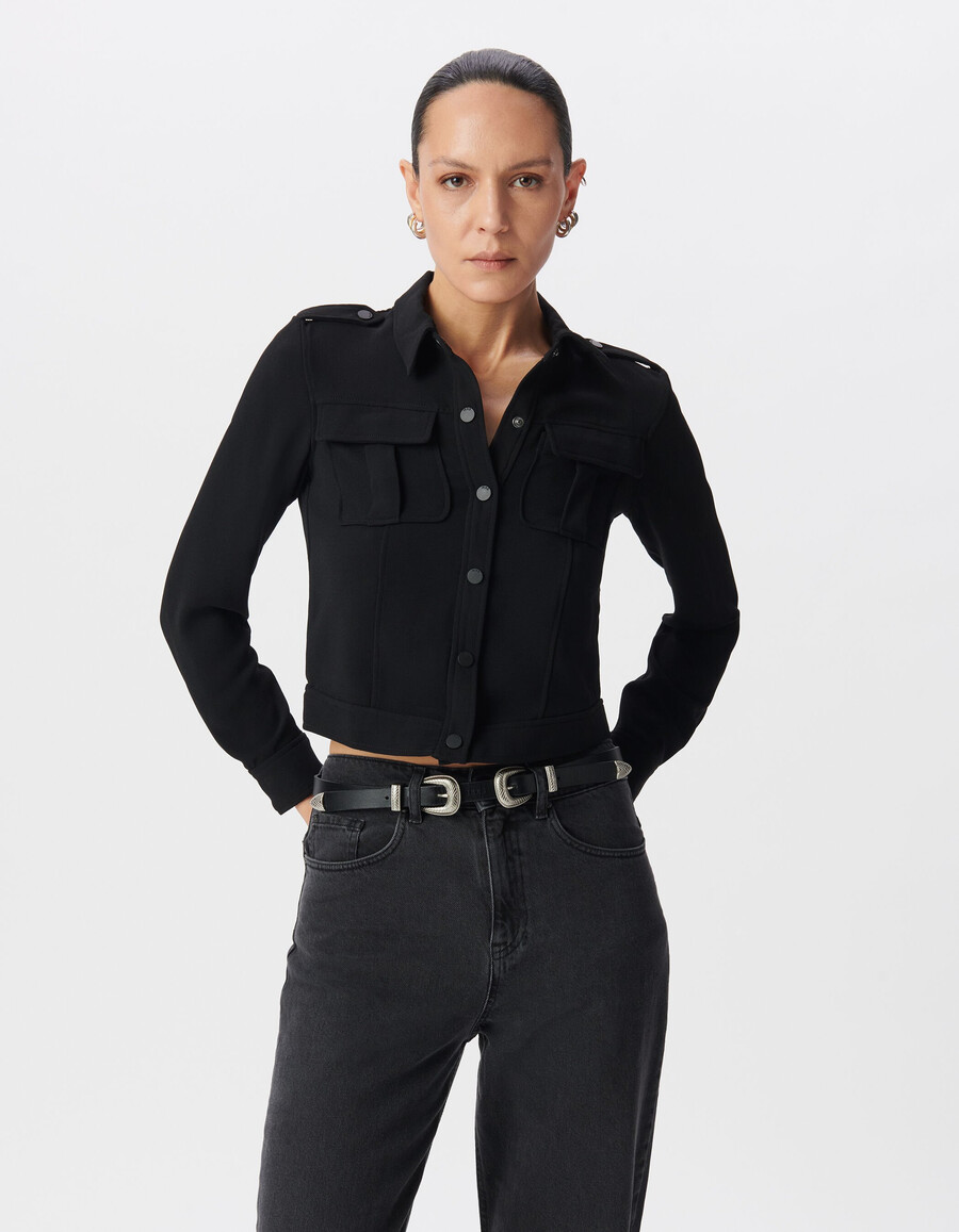 camisa corta negra para mujer con bolsillos de ribete