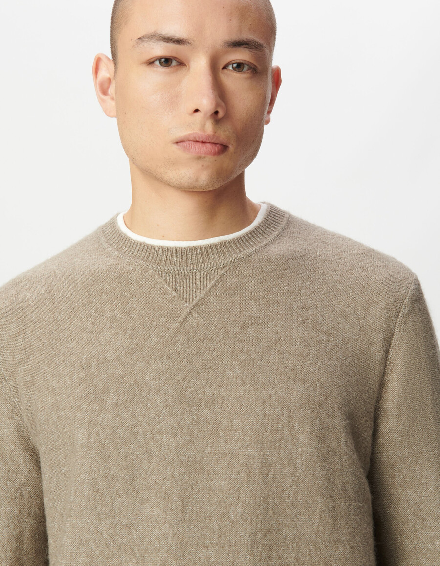 suéter de punto beige para hombre con detalle decorativo en el cuello